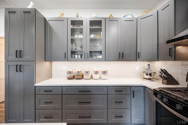 929 Poor House Farm Rd, Amherst, VA 24521 - kitchen featuring stainless steel gas range oven, wall chimney range hood, decorative backsplash, and gray cabinetry