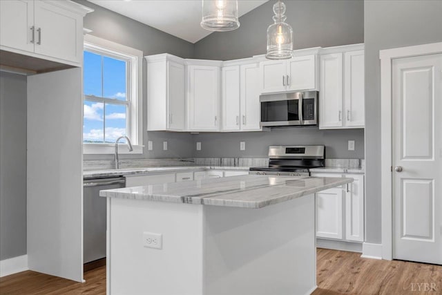 8638 Hat Creek Rd, Brookneal, VA 24528 - kitchen with stainless steel appliances, white cabinetry, a kitchen island, light wood-style floors, and vaulted ceiling