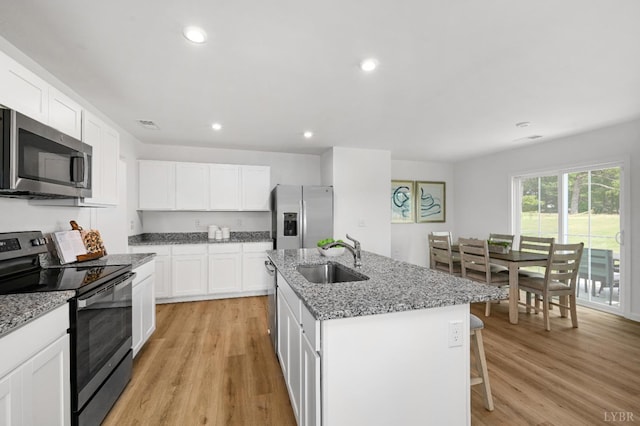 41 Jordan Ct, Lynchburg, VA 24501 - kitchen featuring stainless steel appliances, a sink, light wood finished floors, a center island with sink, and white cabinets