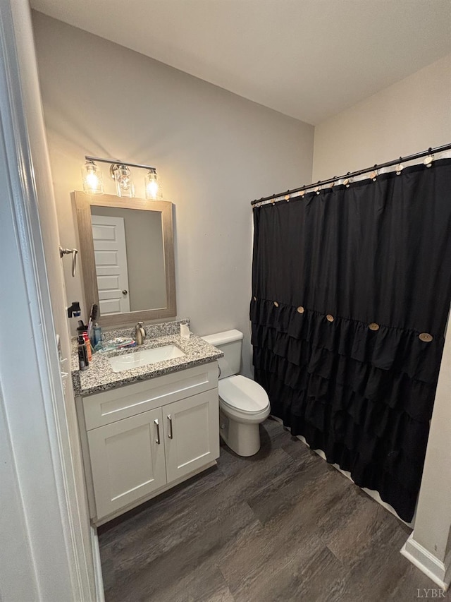 316 E Franklin St, Bedford, VA 24523 - bathroom with wood finished floors, toilet, vanity, and a shower with curtain