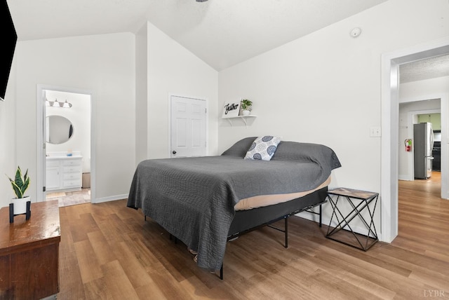 278 Tallyho, Concord, VA 24538 - bedroom with freestanding refrigerator, wood finished floors, vaulted ceiling, baseboards, and connected bathroom