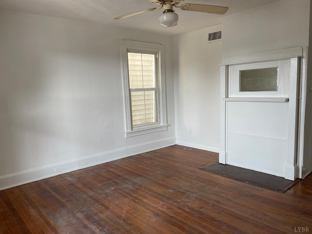 spare room with a ceiling fan, baseboards, and dark wood-style flooring