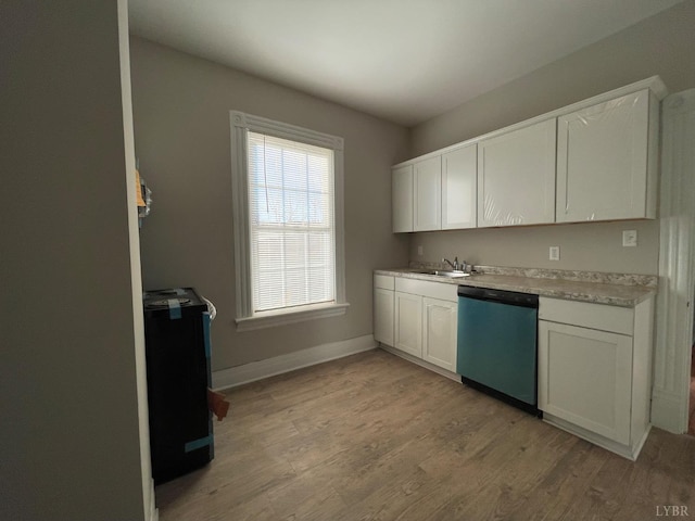 kitchen featuring dishwasher, a sink, and white cabinetry