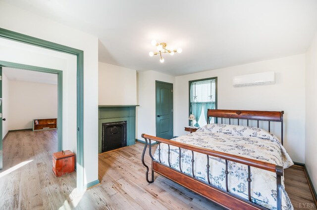 722 Polk St, Lynchburg, VA 24504 - bedroom with a wall unit AC, a fireplace, wood finished floors, and baseboards