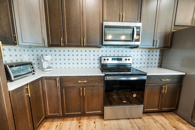 722 Polk St, Lynchburg, VA 24504 - kitchen with stainless steel appliances, light countertops, tasteful backsplash, dark brown cabinetry, and light wood-style flooring