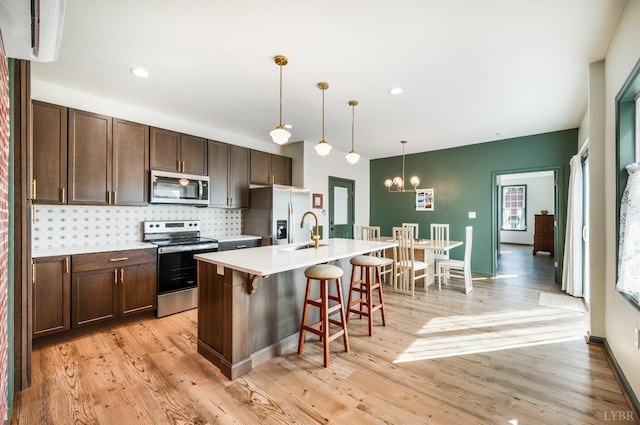 722 Polk St, Lynchburg, VA 24504 - kitchen featuring appliances with stainless steel finishes, dark brown cabinets, a breakfast bar, a center island with sink, and recessed lighting