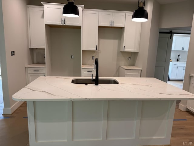 2212 Cambridge Pl, Lynchburg, VA 24503 - kitchen with a sink, white cabinetry, an island with sink, light wood-style flooring, and light stone countertops
