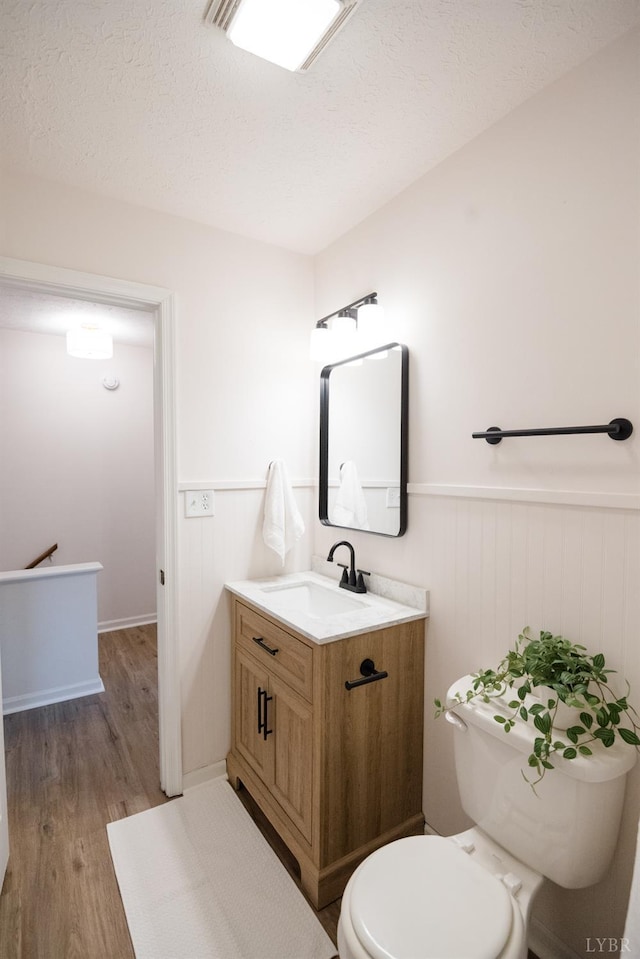 3501 Fort Ave Unit 27, Lynchburg, VA 24501 - half bath with vanity, toilet, wainscoting, wood finished floors, and a textured ceiling
