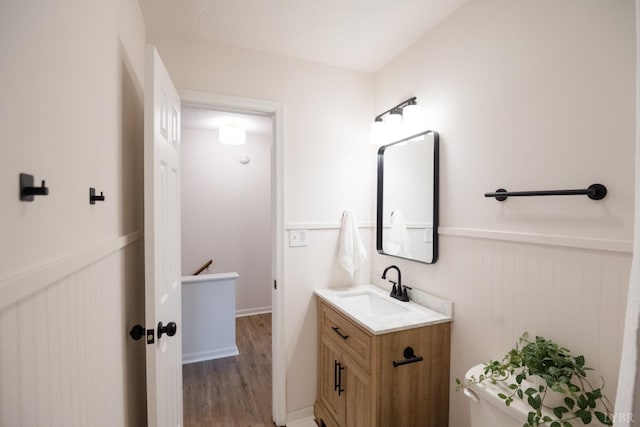 3501 Fort Ave Unit 27, Lynchburg, VA 24501 - bathroom featuring vanity, wainscoting, wood finished floors, and toilet
