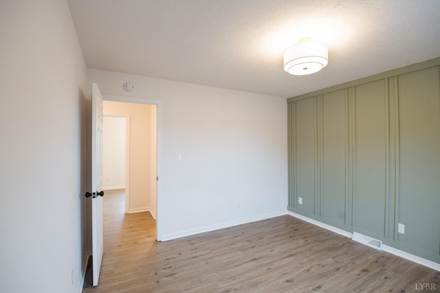 3501 Fort Ave Unit 27, Lynchburg, VA 24501 - unfurnished bedroom with light wood-style flooring, baseboards, and a decorative wall