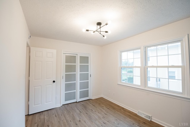 3501 Fort Ave Unit 27, Lynchburg, VA 24501 - spare room with a chandelier, a textured ceiling, wood finished floors, and baseboards