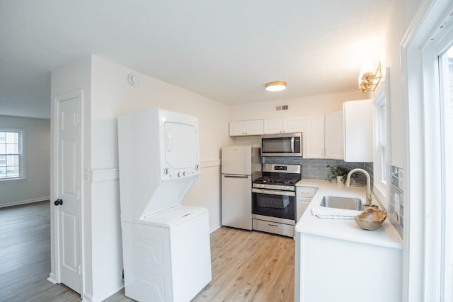 3501 Fort Ave Unit 27, Lynchburg, VA 24501 - kitchen with appliances with stainless steel finishes, estacked washer and dryer, a sink, light wood-style flooring, and light countertops