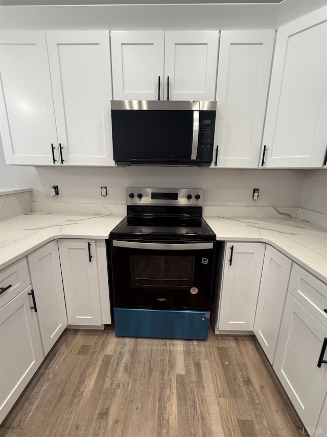 451 Dearborn Rd, Evington, VA 24550 - kitchen featuring stainless steel microwave, black / electric stove, white cabinetry, and light wood finished floors