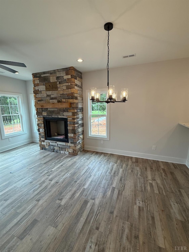 451 Dearborn Rd, Evington, VA 24550 - unfurnished living room featuring a stone fireplace, a chandelier, wood finished floors, and baseboards