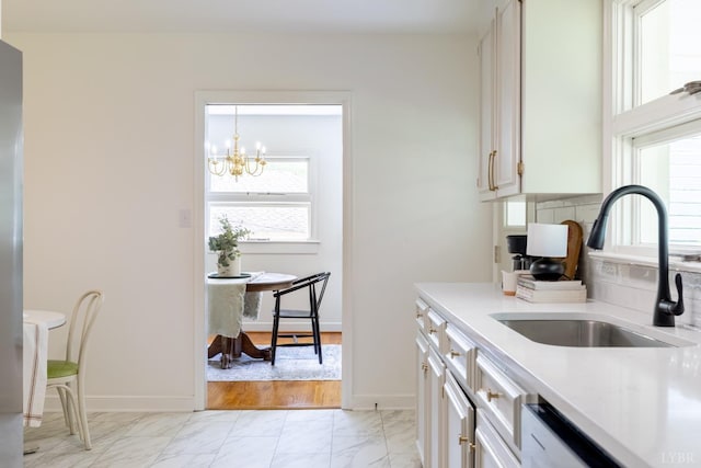 1261 Krise Cir, Lynchburg, VA 24503 - kitchen featuring light marble finish floors, a sink, light countertops, a chandelier, and white cabinets
