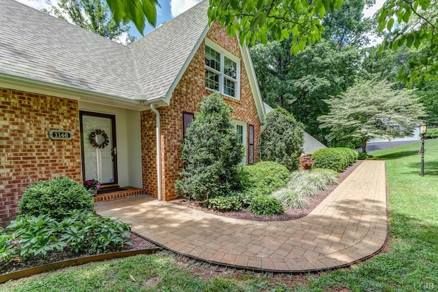 1146 Audubon Dr, Lynchburg, VA 24503 - property entrance with a shingled roof, brick siding, and a yard