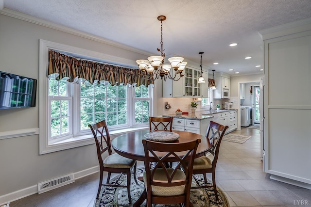 1146 Audubon Dr, Lynchburg, VA 24503 - dining space featuring healthy amount of natural light, a chandelier, ornamental molding, a textured ceiling, and baseboards