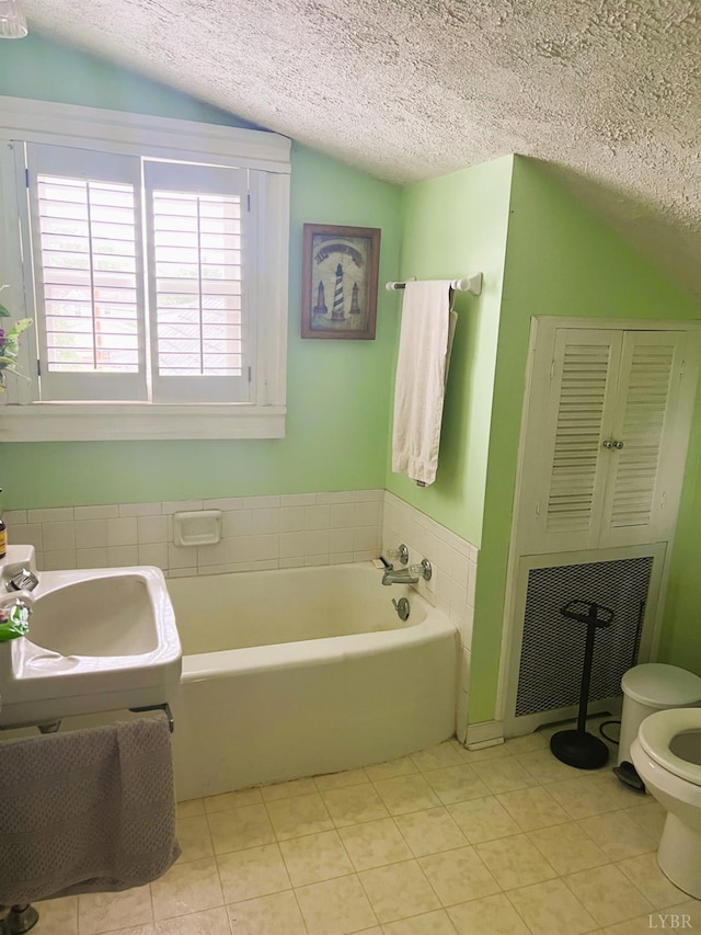901 Bedford Ave, Altavista, VA 24517 - full bath with lofted ceiling, a textured ceiling, a garden tub, toilet, and tile patterned flooring