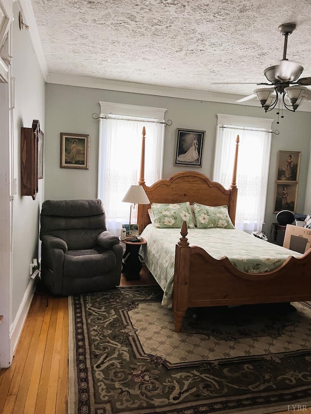 901 Bedford Ave, Altavista, VA 24517 - bedroom featuring multiple windows, crown molding, light wood finished floors, and a textured ceiling