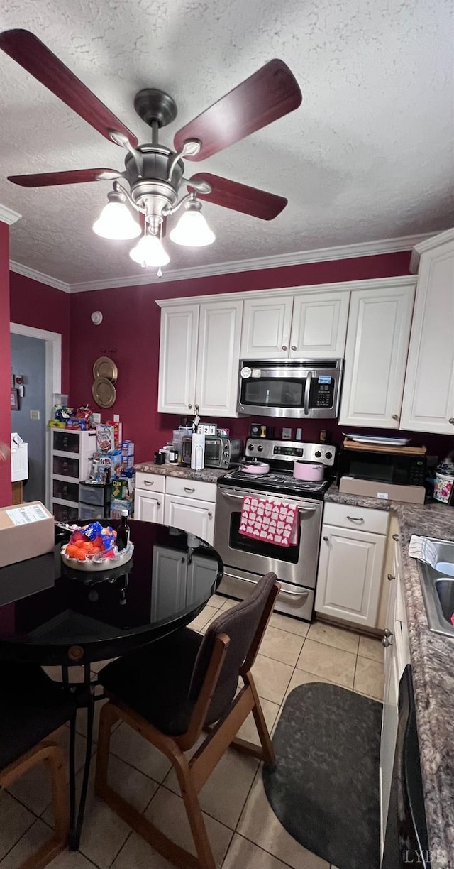 901 Bedford Ave, Altavista, VA 24517 - kitchen with stainless steel appliances, ceiling fan, white cabinetry, light tile patterned flooring, and a textured ceiling
