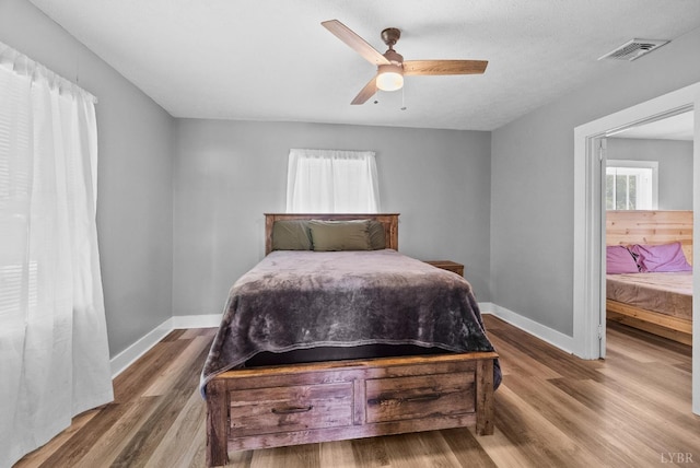 200 Jasper Wood Rd, Hurt, VA 24563 - bedroom with multiple windows, baseboards, wood finished floors, and a ceiling fan