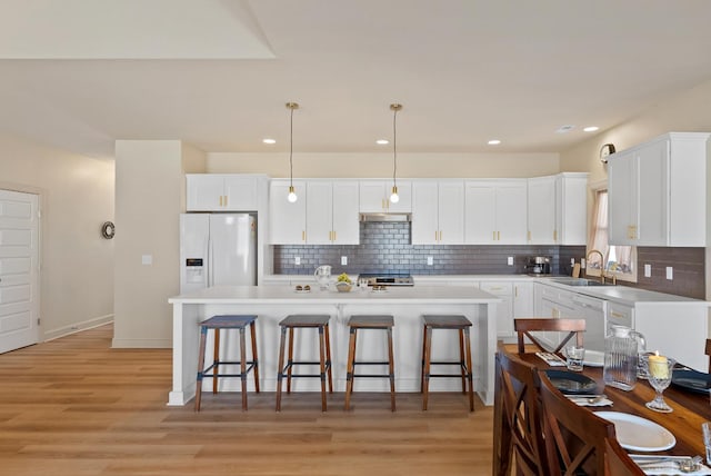 1268 Stoney Ridge Blvd, Forest, VA 24551 - kitchen with white refrigerator with ice dispenser, a sink, decorative backsplash, a kitchen bar, and white cabinetry