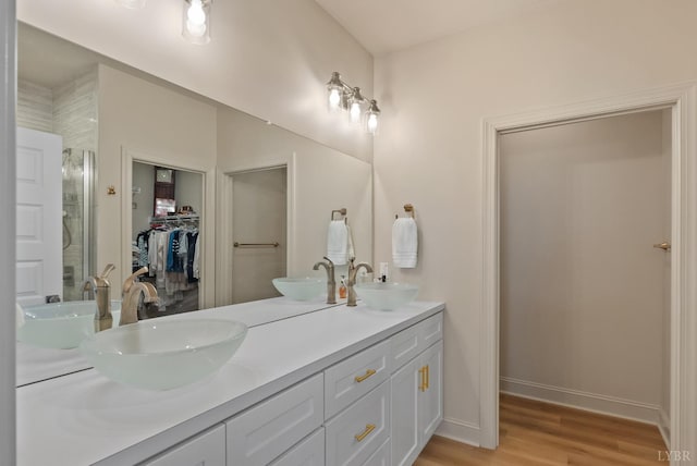 1268 Stoney Ridge Blvd, Forest, VA 24551 - full bathroom with double vanity, a spacious closet, wood finished floors, a shower with shower door, and baseboards