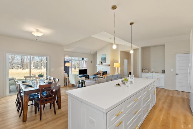 1268 Stoney Ridge Blvd, Forest, VA 24551 - kitchen with a kitchen island, light wood-style floors, white cabinetry, decorative light fixtures, and lofted ceiling