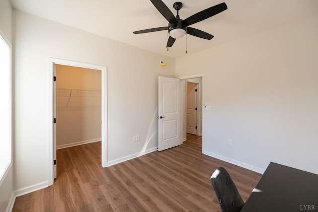128 Brenleigh Ct Unit 105, Lynchburg, VA 24501 - unfurnished bedroom featuring light wood-type flooring, a walk in closet, baseboards, a closet, and ceiling fan