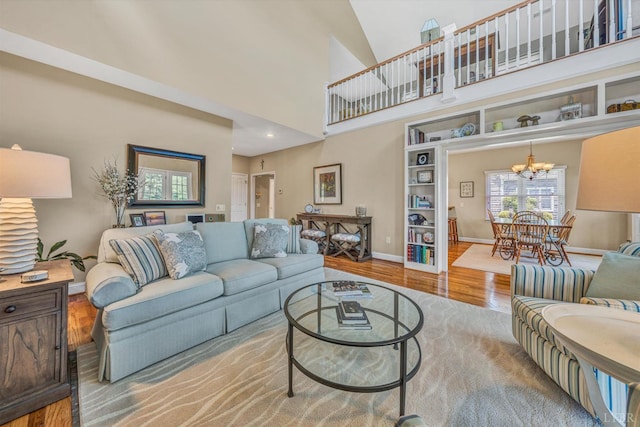 145 Golfers Crossing Dr, Penhook, VA 24137 - living area featuring wood finished floors, plenty of natural light, a chandelier, baseboards, and a high ceiling