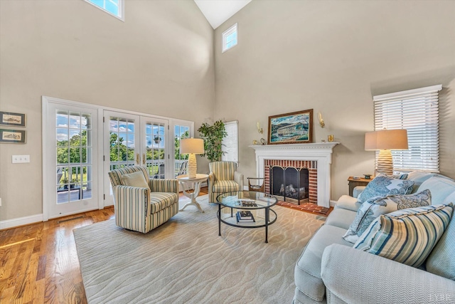 145 Golfers Crossing Dr, Penhook, VA 24137 - living area featuring wood finished floors, a fireplace, baseboards, high vaulted ceiling, and french doors