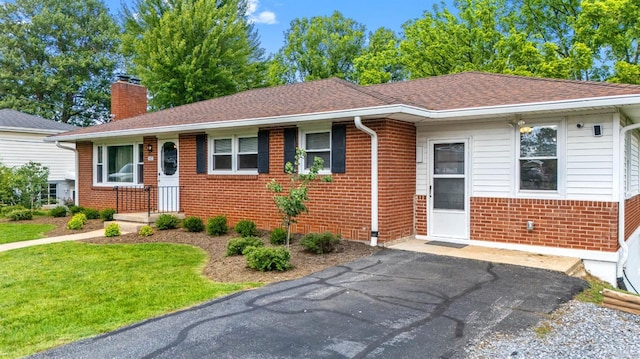 147 Maple Dr, Madison Heights, VA 24572 - view of front of home with a chimney, brick siding, roof with shingles, and a front lawn