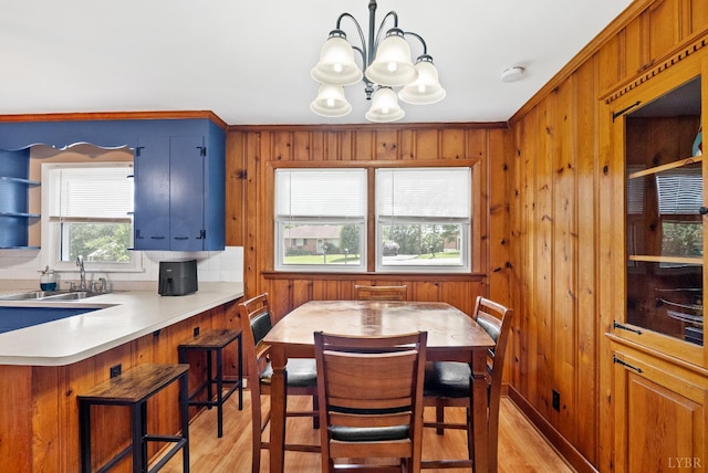 147 Maple Dr, Madison Heights, VA 24572 - dining room featuring light wood-type flooring, a chandelier, wood walls, and ornamental molding