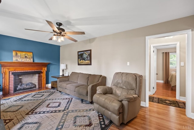 147 Maple Dr, Madison Heights, VA 24572 - living area featuring wood finished floors, a ceiling fan, a brick fireplace, and baseboards