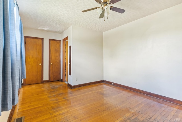 10662 Lee Jackson Hwy, Big Island, VA 24526 - empty room with baseboards, hardwood / wood-style flooring, a ceiling fan, and a textured ceiling