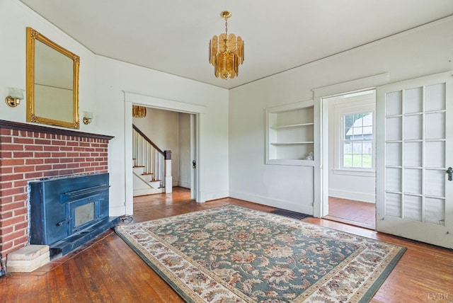 10662 Lee Jackson Hwy, Big Island, VA 24526 - unfurnished living room featuring stairs, hardwood / wood-style floors, baseboards, a chandelier, and built in features