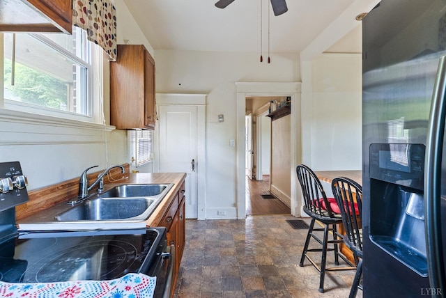 10662 Lee Jackson Hwy, Big Island, VA 24526 - kitchen with stainless steel refrigerator with ice dispenser, range with electric stovetop, brown cabinets, stone finish floors, and a ceiling fan