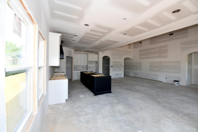 24 Stony Ridge Blvd, Forest, VA 24551 - kitchen featuring arched walkways, concrete floors, white cabinetry, a kitchen island, and open floor plan