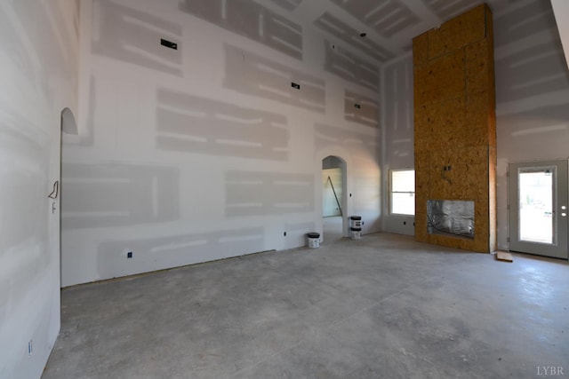 24 Stony Ridge Blvd, Forest, VA 24551 - unfurnished living room with concrete floors, arched walkways, and a towering ceiling