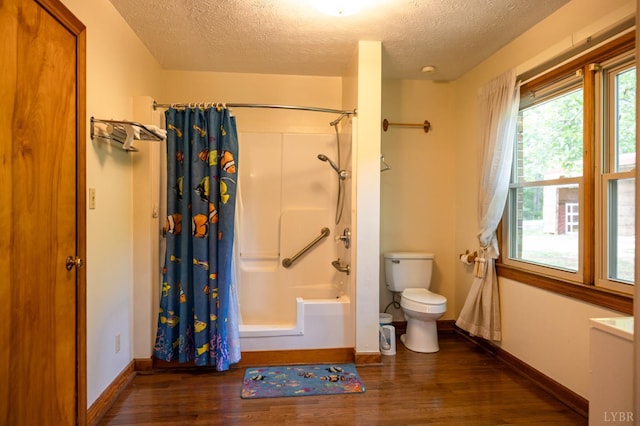 20586 Kings Hwy, Randolph, VA 23962 - bathroom featuring a textured ceiling, wood finished floors, toilet, shower / bath combo with shower curtain, and baseboards