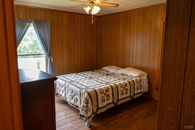 20586 Kings Hwy, Randolph, VA 23962 - bedroom featuring wooden walls, wood finished floors, ceiling fan, and a textured ceiling