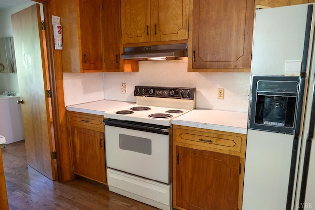 20586 Kings Hwy, Randolph, VA 23962 - kitchen with white appliances, under cabinet range hood, light countertops, brown cabinets, and dark wood-style flooring
