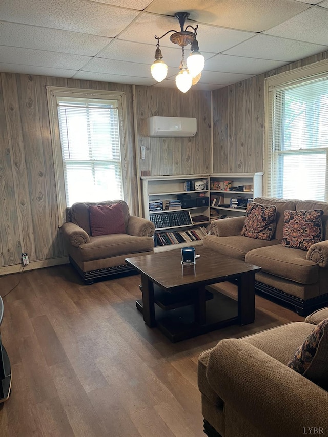 1115 Jackson St, Lynchburg, VA 24504 - living room featuring a paneled ceiling, a wall mounted AC, healthy amount of natural light, wood walls, and wood finished floors