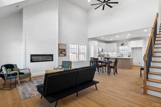 179 Meadow Brook Cir, Danville, VA 24541 - living area featuring stairs, light wood finished floors, a fireplace, high vaulted ceiling, and recessed lighting