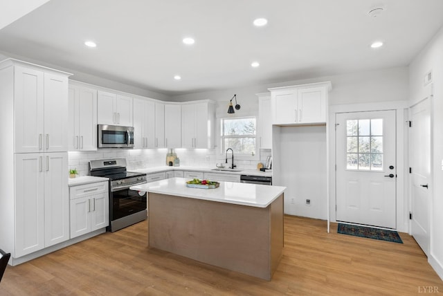 179 Meadow Brook Cir, Danville, VA 24541 - kitchen featuring appliances with stainless steel finishes, white cabinetry, light countertops, tasteful backsplash, and a kitchen island