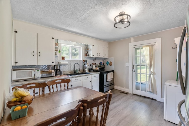 400 Blue Ridge St, Lynchburg, VA 24501 - kitchen featuring stainless steel appliances, a sink, open shelves, backsplash, and light wood-type flooring