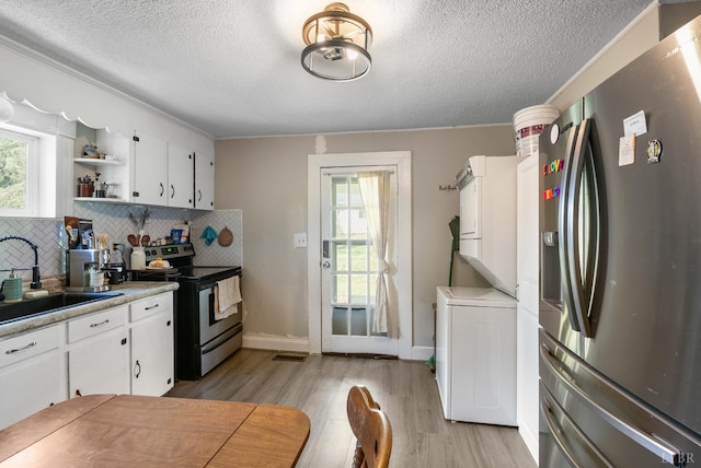 400 Blue Ridge St, Lynchburg, VA 24501 - kitchen with appliances with stainless steel finishes, a sink, estacked washer and dryer, a textured ceiling, and light wood finished floors