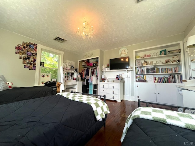 221 Castle Craig Dr, Evington, VA 24550 - bedroom featuring a textured ceiling, wood finished floors, a closet, and a chandelier