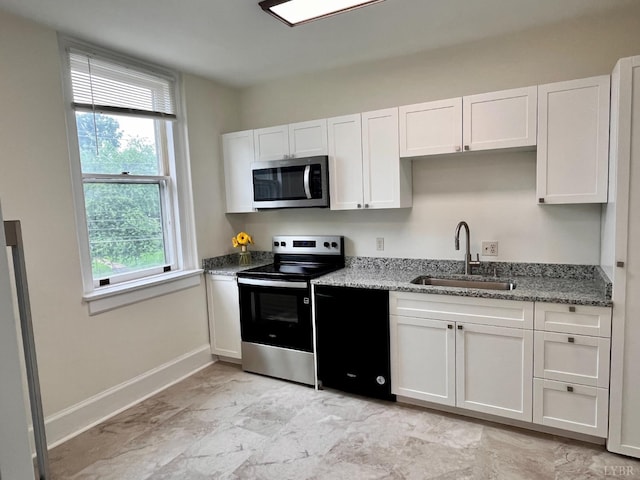 2910 Rivermont Ave Unit 301, Lynchburg, VA 24503 - kitchen with stainless steel appliances, a sink, white cabinets, light stone countertops, and baseboards