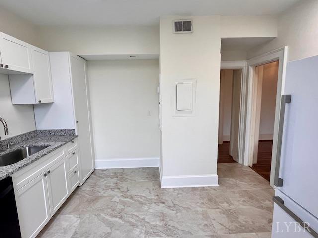 2910 Rivermont Ave Unit 301, Lynchburg, VA 24503 - kitchen featuring a sink, dishwasher, light stone counters, white cabinets, and baseboards